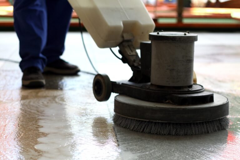 Ride-on floor scrubber cleaning a hard commercial floor