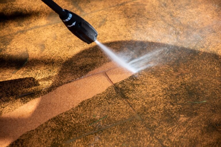 Pressure washing built-up grime from commercial paving