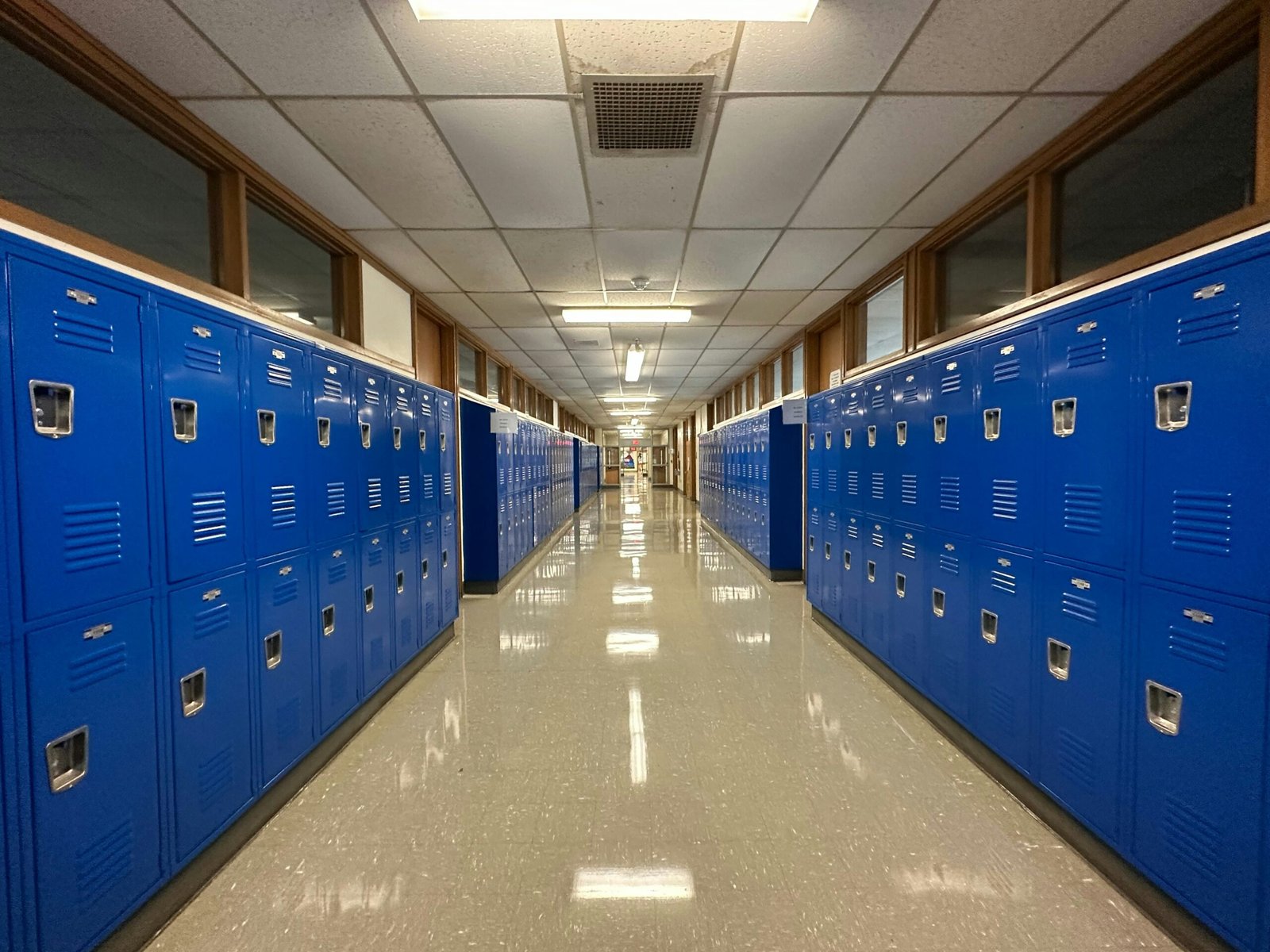 Clean school hallway lined with blue lockers