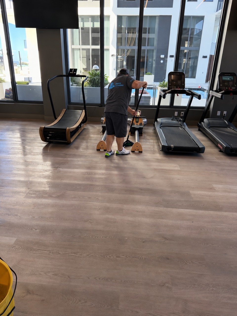 Eriko’s Cleaning team member cleaning the floor around fitness equipment